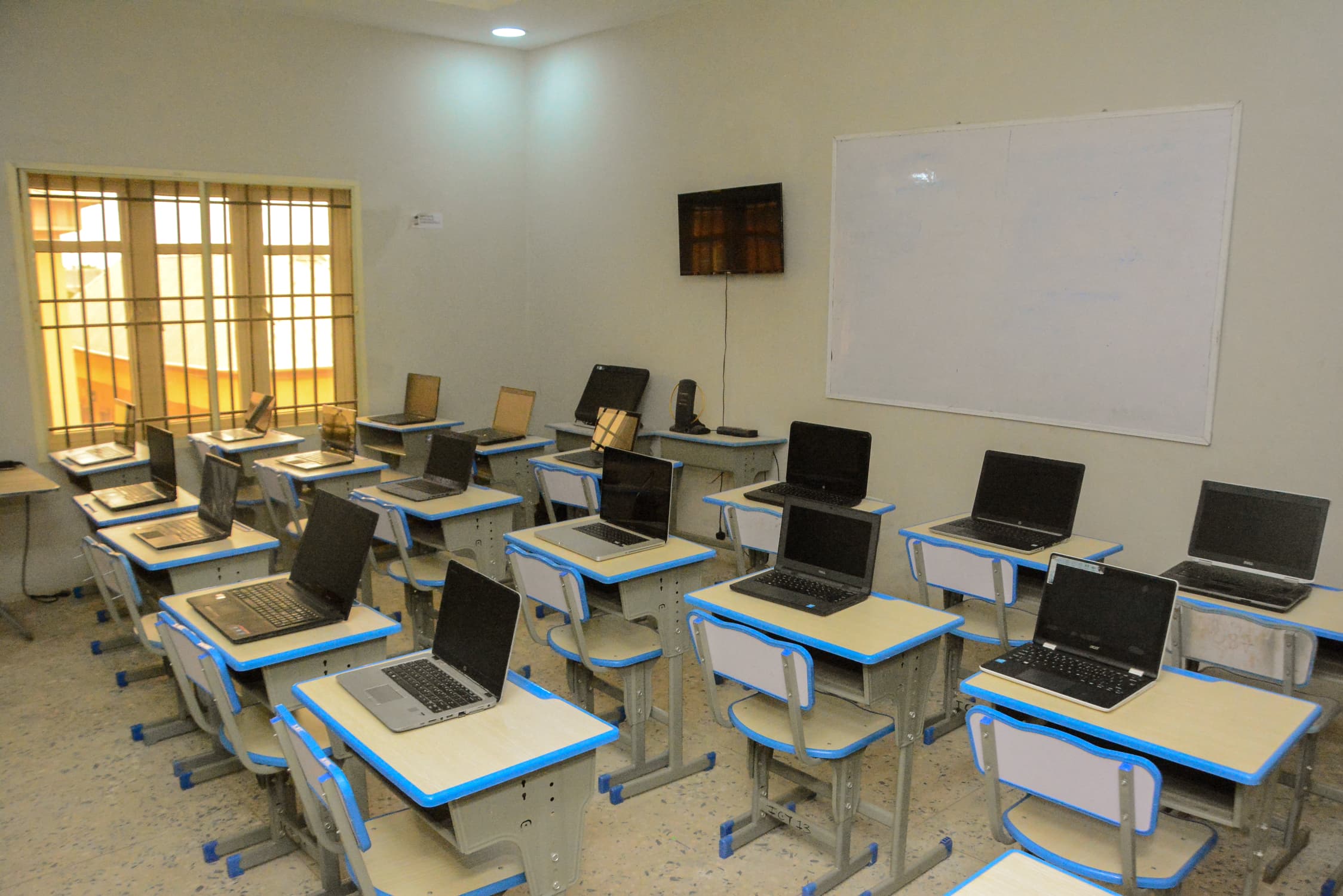 ICT Room with rows of student laptops, a wall-mounted screen, and a whiteboard